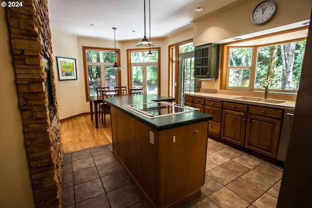 kitchen featuring black electric stovetop, a kitchen island with sink, sink, pendant lighting, and dark tile patterned flooring