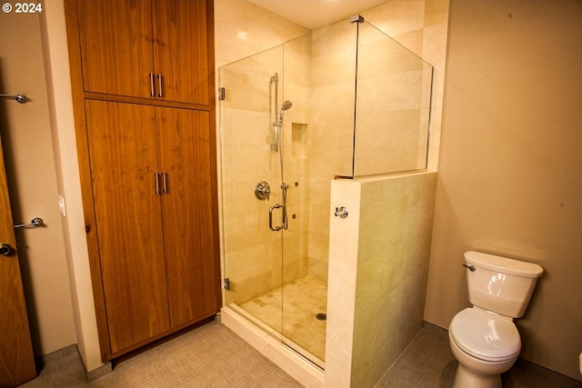 bathroom with tile patterned flooring, toilet, and an enclosed shower