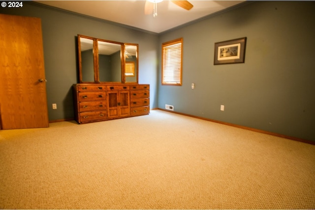 unfurnished bedroom featuring crown molding, ceiling fan, and light colored carpet