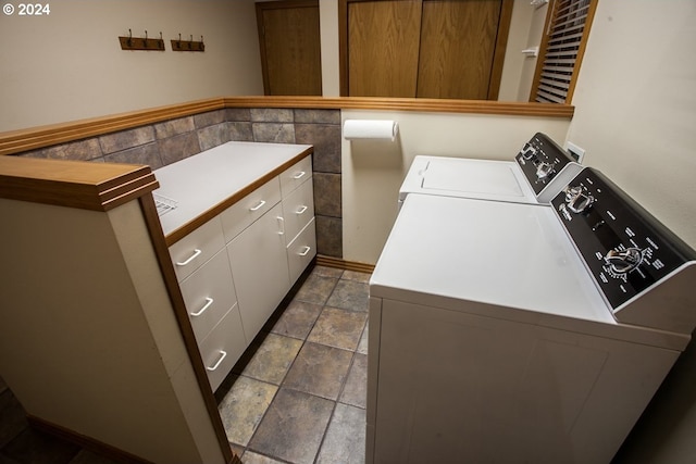 clothes washing area with cabinets and separate washer and dryer