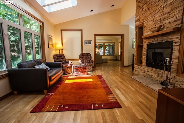 living room with a skylight, a fireplace, high vaulted ceiling, and wood-type flooring