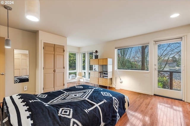 bedroom with two closets, light wood-style floors, recessed lighting, baseboards, and ensuite bathroom
