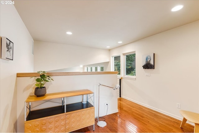bedroom with multiple windows, wood finished floors, and baseboards