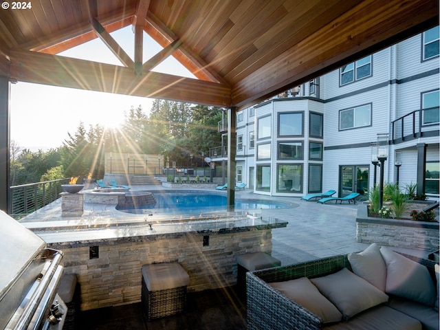 view of pool featuring a patio area and an outdoor living space with a fire pit