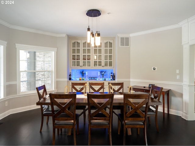 dining room with an inviting chandelier, crown molding, dark hardwood / wood-style flooring, and indoor bar