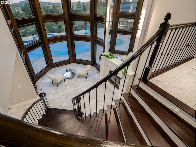 stairway with expansive windows and a healthy amount of sunlight