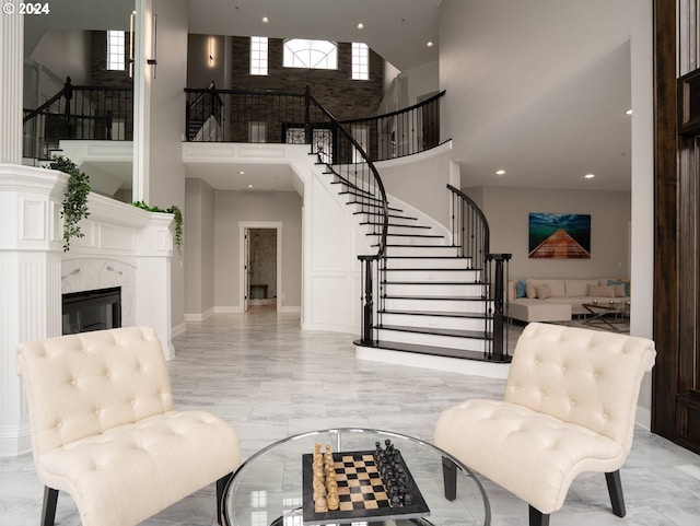 entryway featuring a premium fireplace and a high ceiling