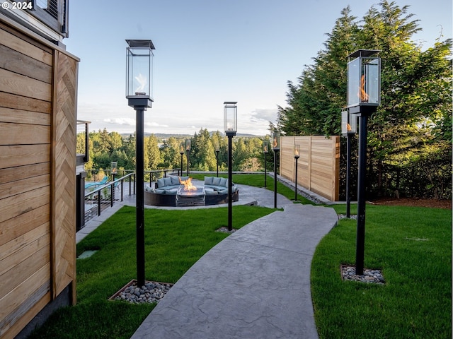 view of home's community featuring an outdoor living space with a fire pit and a yard