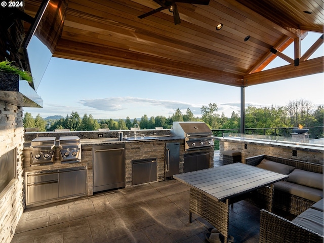 view of patio featuring a grill, ceiling fan, and an outdoor kitchen