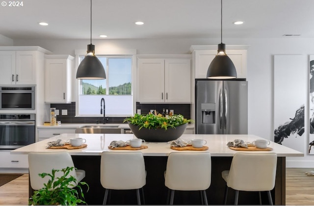 kitchen with decorative backsplash, a center island, stainless steel fridge with ice dispenser, and white cabinetry