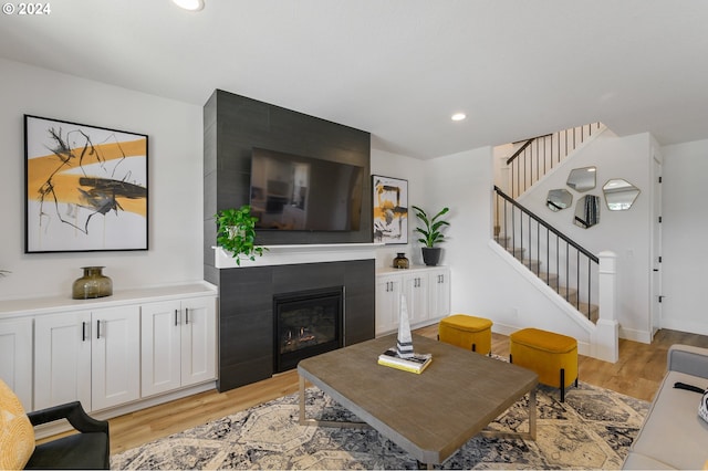 living room with light hardwood / wood-style floors and a tile fireplace