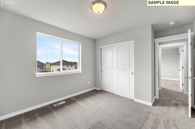 unfurnished bedroom featuring carpet floors and a closet