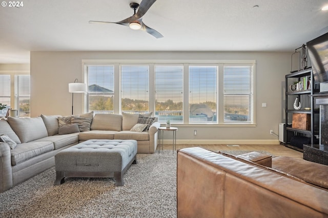 living room with ceiling fan and a healthy amount of sunlight