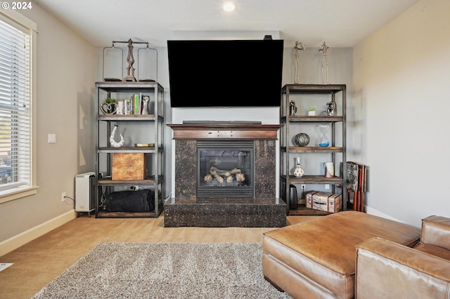 carpeted living room with a premium fireplace