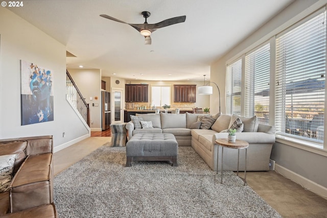 carpeted living room featuring ceiling fan