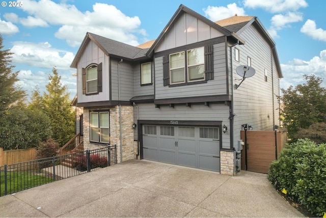 view of front facade featuring stone siding, fence, board and batten siding, and driveway