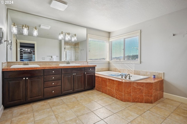 bathroom featuring vanity, separate shower and tub, a textured ceiling, and tile patterned flooring