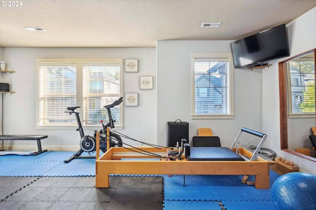 exercise room with a textured ceiling and a wealth of natural light