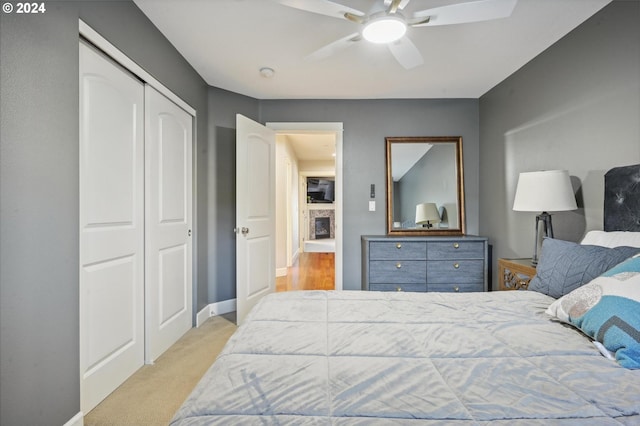 bedroom featuring light carpet, a closet, and ceiling fan