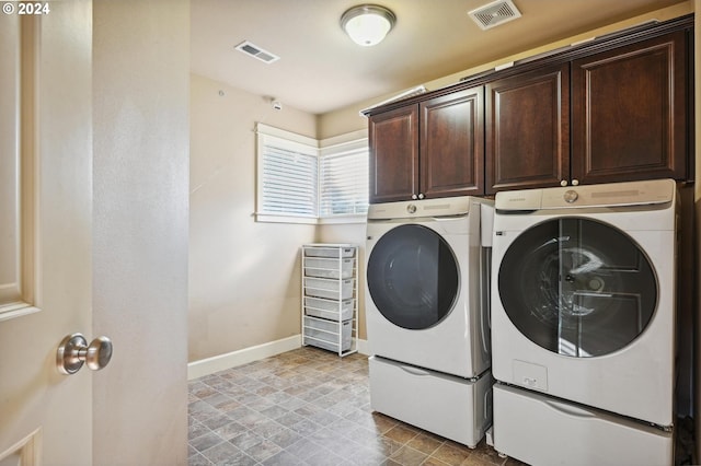 laundry area with washer and dryer and cabinets