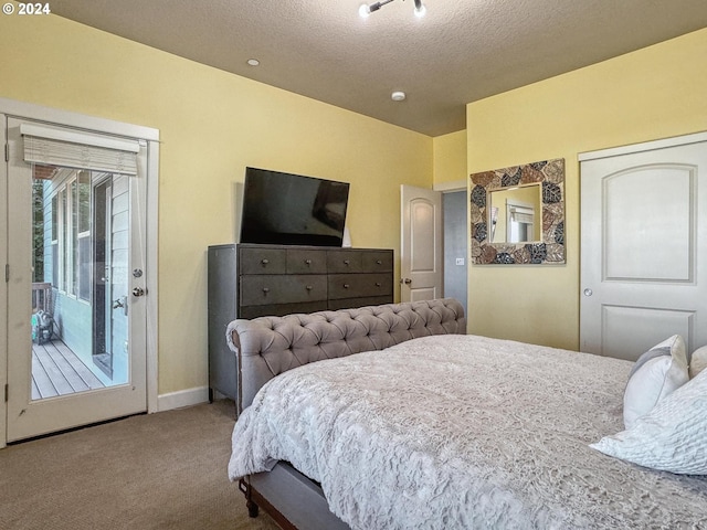 bedroom with carpet, access to outside, and a textured ceiling