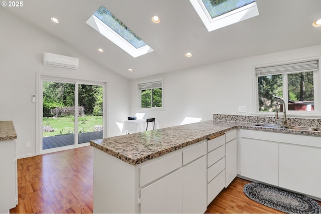 24221 Warthen Rd, Elmira, OR 97437 - kitchen with a sink, a skylight, a wall mounted air conditioner, a peninsula, and lofted ceiling