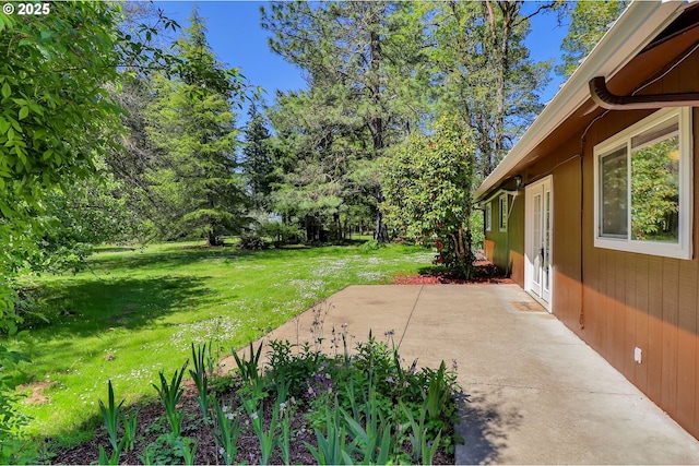 view of grassy yard with a patio area and french doors