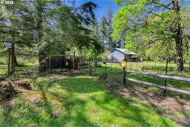 view of yard featuring fence and an outbuilding