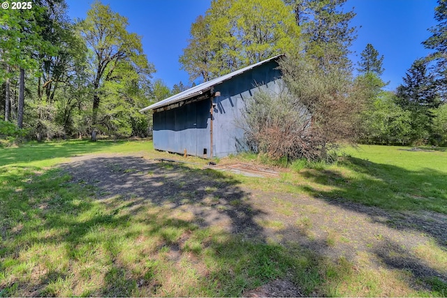 view of property exterior featuring a lawn and an outdoor structure