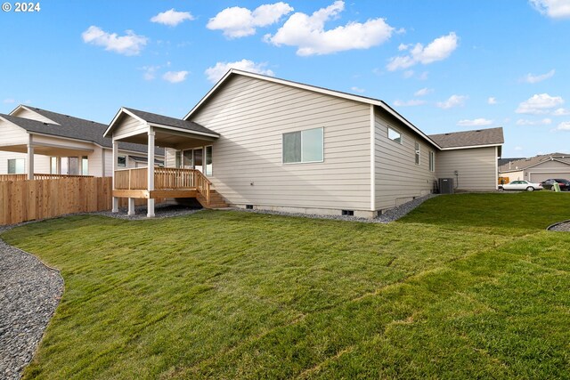 back of house with a lawn, a wooden deck, and cooling unit