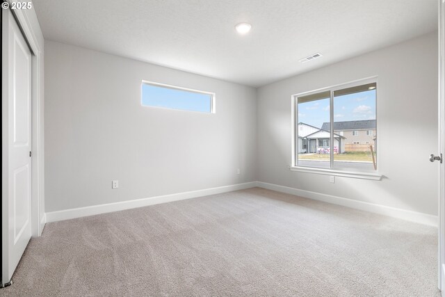 unfurnished bedroom featuring light carpet and a closet