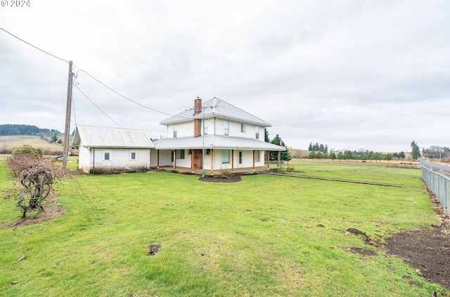 farmhouse inspired home featuring covered porch, a rural view, and a front yard