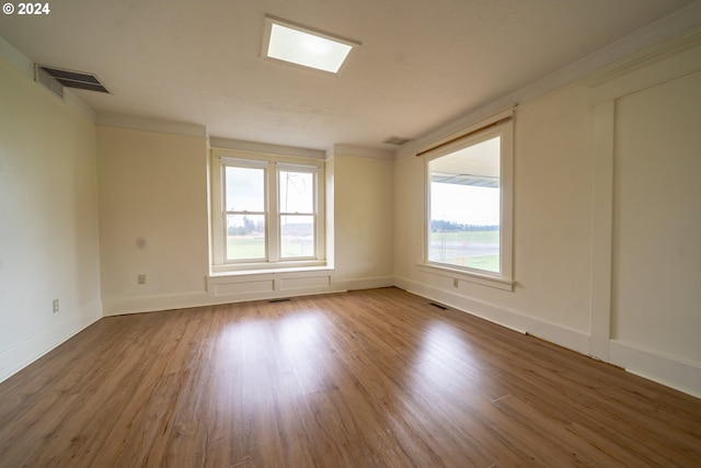 spare room with hardwood / wood-style floors and a healthy amount of sunlight