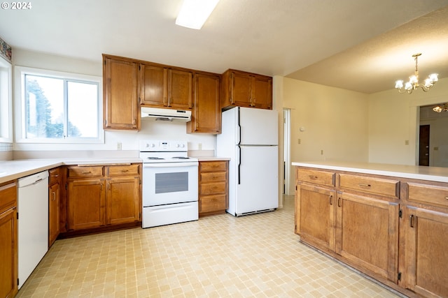 kitchen with pendant lighting, white appliances, and a notable chandelier