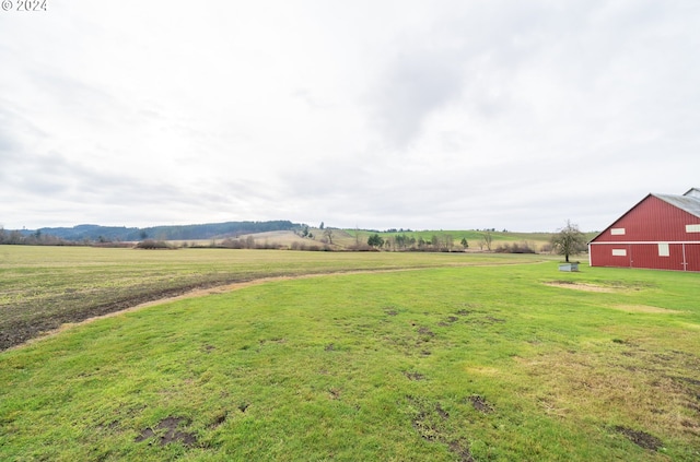 view of yard with a rural view and an outdoor structure