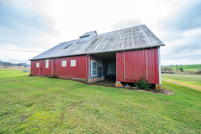 back of house with a lawn and an outbuilding