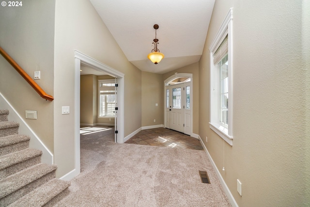 carpeted foyer entrance with lofted ceiling