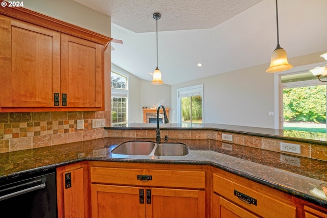 kitchen with dark stone counters, tasteful backsplash, sink, lofted ceiling, and hanging light fixtures