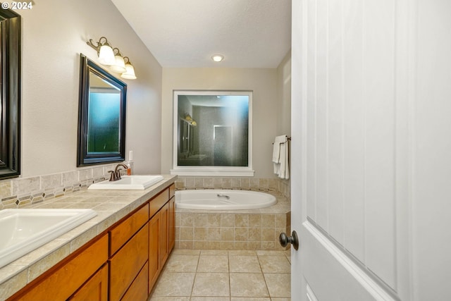 bathroom with tile patterned flooring, a textured ceiling, vanity, and separate shower and tub