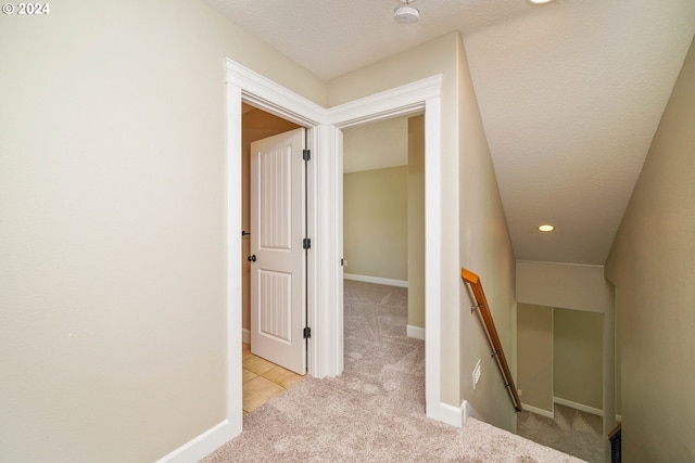 staircase featuring a textured ceiling and carpet