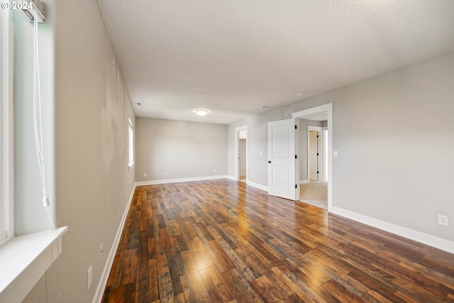 unfurnished room featuring a textured ceiling and dark hardwood / wood-style floors