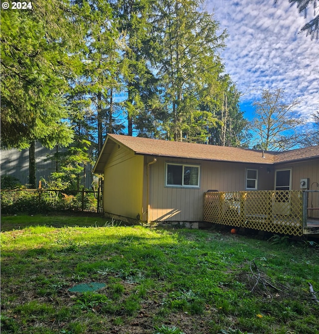 rear view of property featuring a lawn and a wooden deck