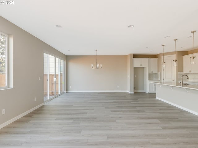 unfurnished living room with light wood-type flooring and plenty of natural light