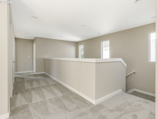 hallway with light carpet and a wealth of natural light