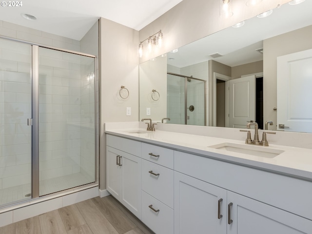 bathroom with hardwood / wood-style flooring, walk in shower, and vanity