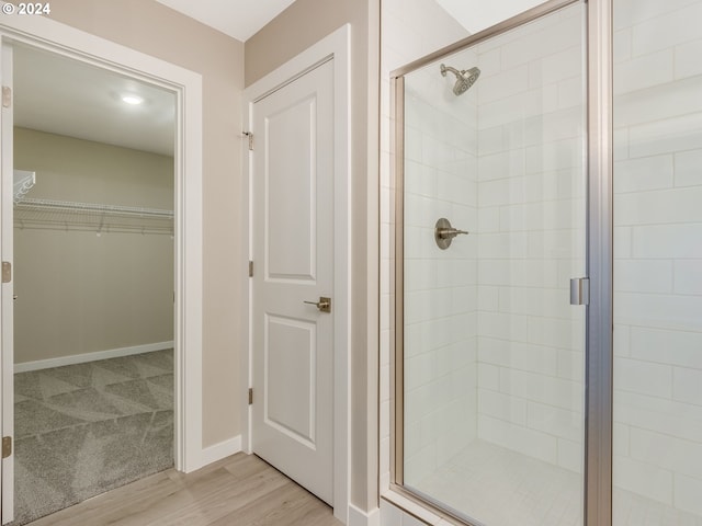 bathroom featuring hardwood / wood-style flooring and a shower with shower door