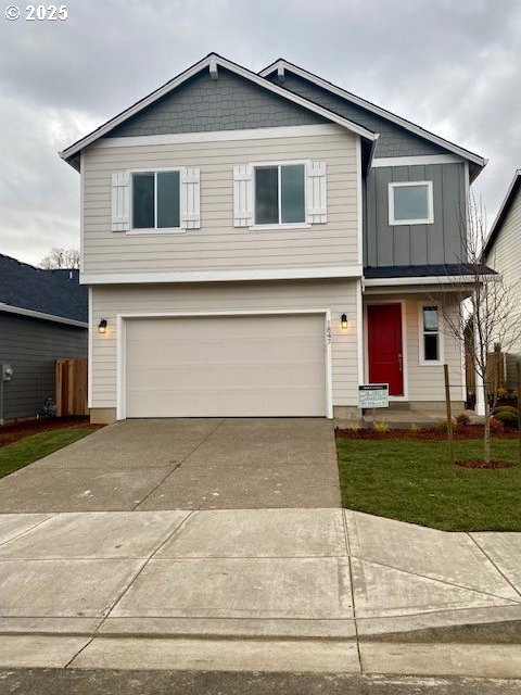 view of front of house featuring board and batten siding, driveway, and a garage