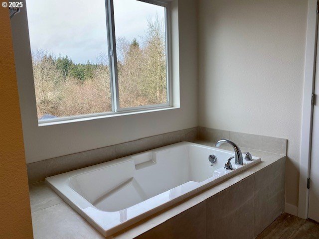 bathroom featuring a relaxing tiled tub