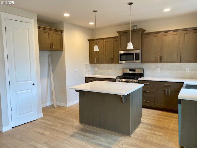 kitchen featuring hanging light fixtures, tasteful backsplash, sink, and dishwashing machine