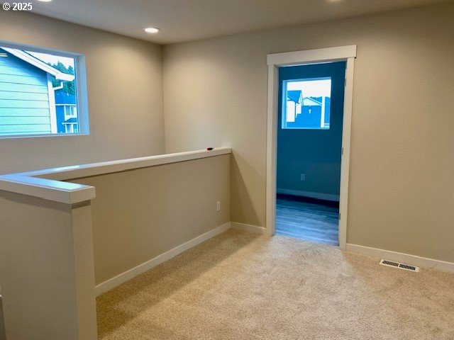 corridor featuring recessed lighting, light colored carpet, an upstairs landing, baseboards, and visible vents